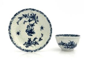 A Worcester blue and white tea bowl and saucer, workmans marks, circa 1757, in the Feather Mould