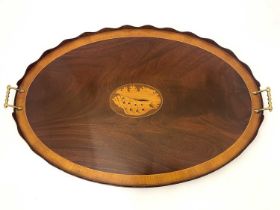 A George III mahogany and boxwood inlaid twin handled tray, oval form, with wave cut gallery