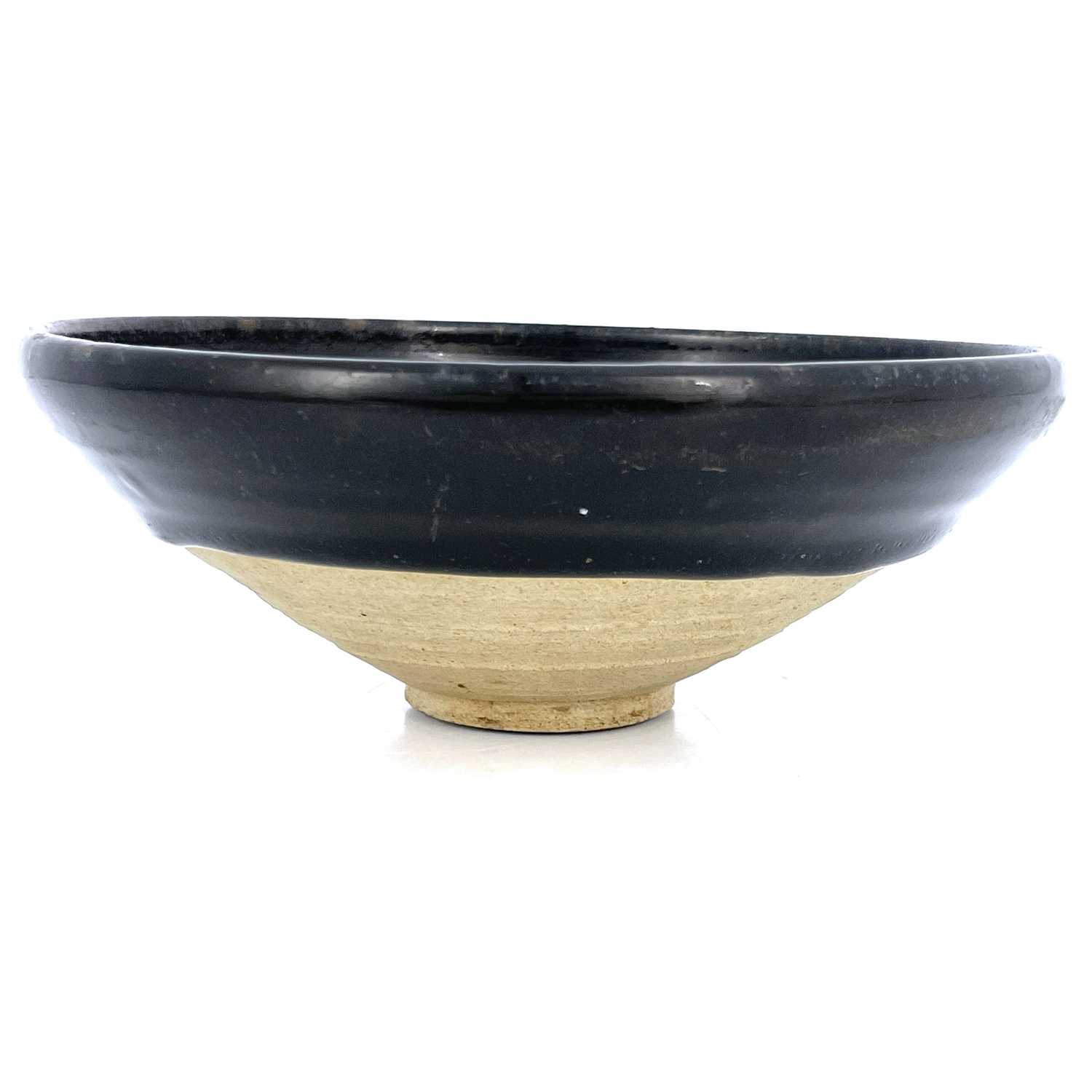 A Chinese Jian type black glazed bowl, probably Southern Song dynasty, conical with dipped glaze,
