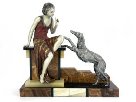 An Art Deco patinated art metal figure group, circa 1930, modelled as a woman sitting on a plinth