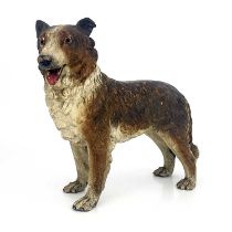 A cold painted pottery figure of a dog, in the Goldscheider style, realistically modelled and set