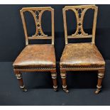 A pair of 19th century leather and mahogany dining chairs, front casters