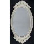 An oval white painted contemporary wall mirror, H.94cm W.50cm