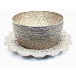 An early 20th century large Burmese or Thai silver bowl with matching plate, repousse embossed