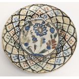 A fine 16th century Persian kubachi glazed pottery dish with floral decoration, D.21.5cm