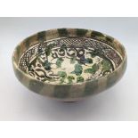 A rare 12-13th century Persian Garus ware pottery bowl depicting a ram amongst foliage H.11cm D.