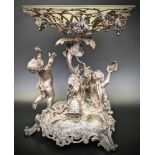 A Victorian silver centrepiece, domed rococo base on three scrolling feet, supporting a pastoral