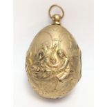 A cast gilt metal egg depicting a Nativity scene to one side and Christ Risen to the other, hinged