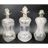 A collection of 3 Edwardian silver and glass glug decanters, all London hallmarks, H.31cm (