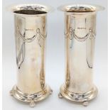 A pair of early 20th century Neo-Classical style silver vases, cylindrical with an embossed band