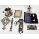 A collection of silver items to include an Arts and Crafts three handled pot, a tea strainer, a