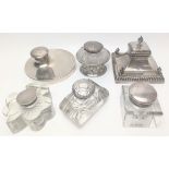 A collection of six early 20th century silver and glass inkwells, all British hallmarks including an