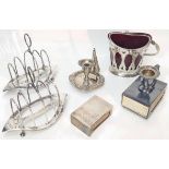 A collection of silver items to include a pair of toast racks, a swing handle basket with