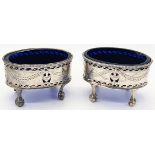 A pair of George III silver salts, pierced bodies, raised on four claw and ball feet, monogrammed,
