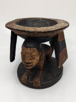 A Nigerian African tribal wooden carved Yoruba Division bowl supported by a nude crawling figure,