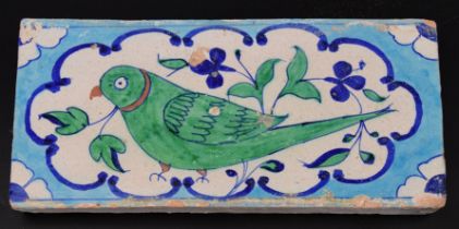 A fine early 19th century North Indian Multan tile depicting a green parrot, 30cm x 15cm