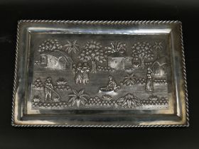 A large 19th century Indian Calcutta silver tray depicting village scenes, 21cm x 31cm