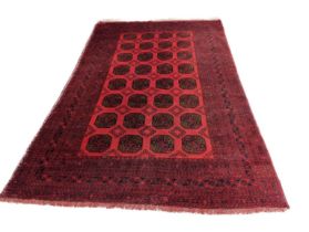 A large Afghan red ground bokhara rug, 312cm x 207cm