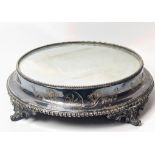 A large Edwardian silver plated cake stand, raised on splay feet, mirrored top, D.36cm