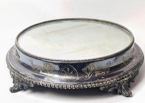 A large Edwardian silver plated cake stand, raised on splay feet, mirrored top, D.36cm