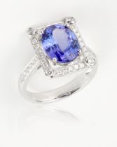 A tanzanite and diamond ring, 4.36cts oval cut stone within square shaped mount, mounted on 18ct