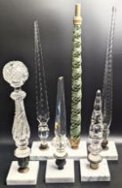 A collection of 6 large glass finials mounted on square marble bases