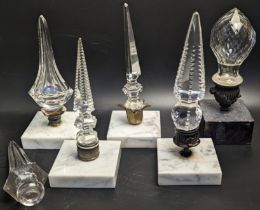 A collection of 5 glass finials mounted on square marble bases