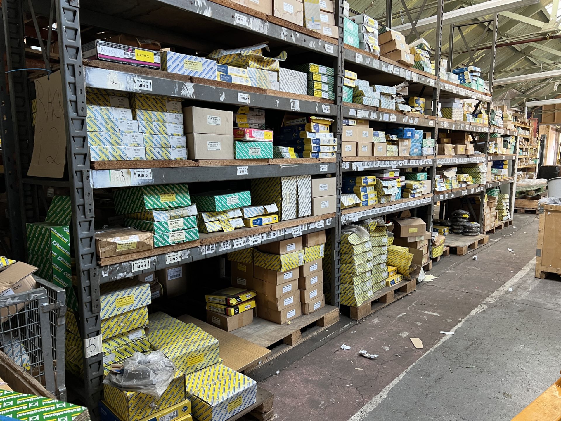 A Large Quantity of Brake Discs Situated on One Side of Pallet Racking as shown. This lot contains