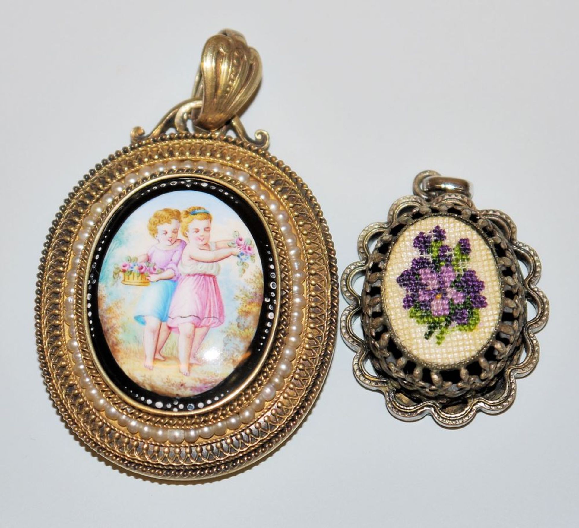 Two pendants of the 19th century with porcelain and embroidery, gold a.o.