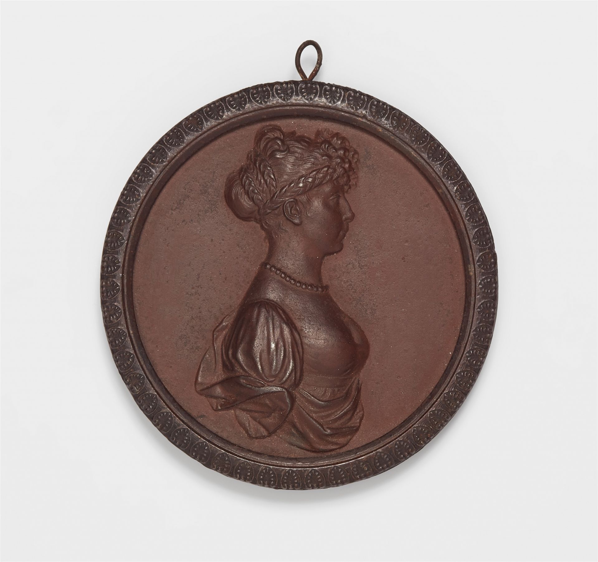A cast iron plaque with a portrait of Queen Louise