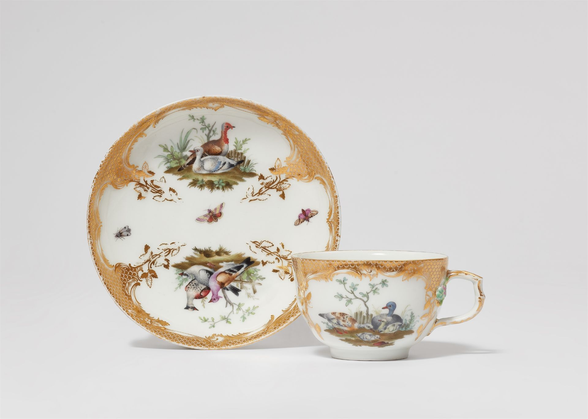 A Berlin KPM porcelain teacup and saucer from a service with gold scale pattern decor