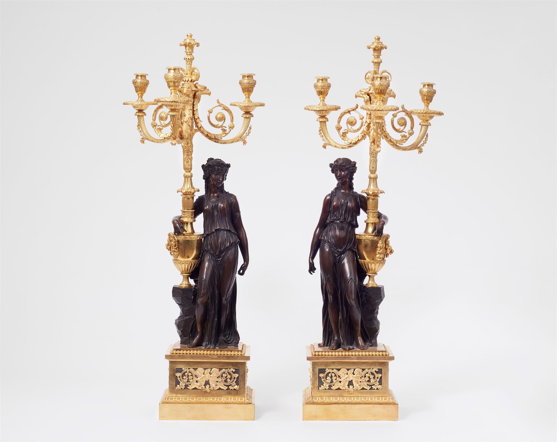 A pair of sculptural ormolu candelabra, after a model by Clodion