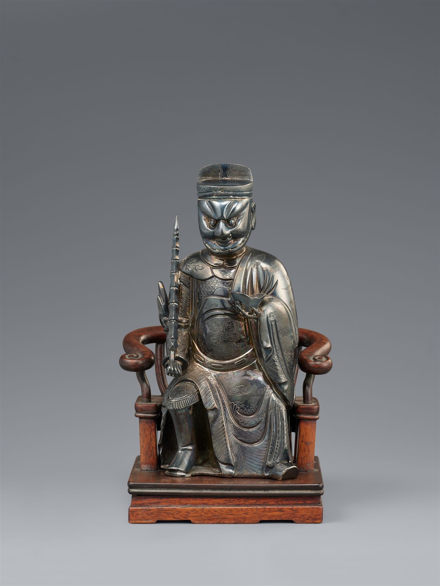 A hollow-cast silver figure of a dignitary on a wooden chair. Shanghai. Around 1900
