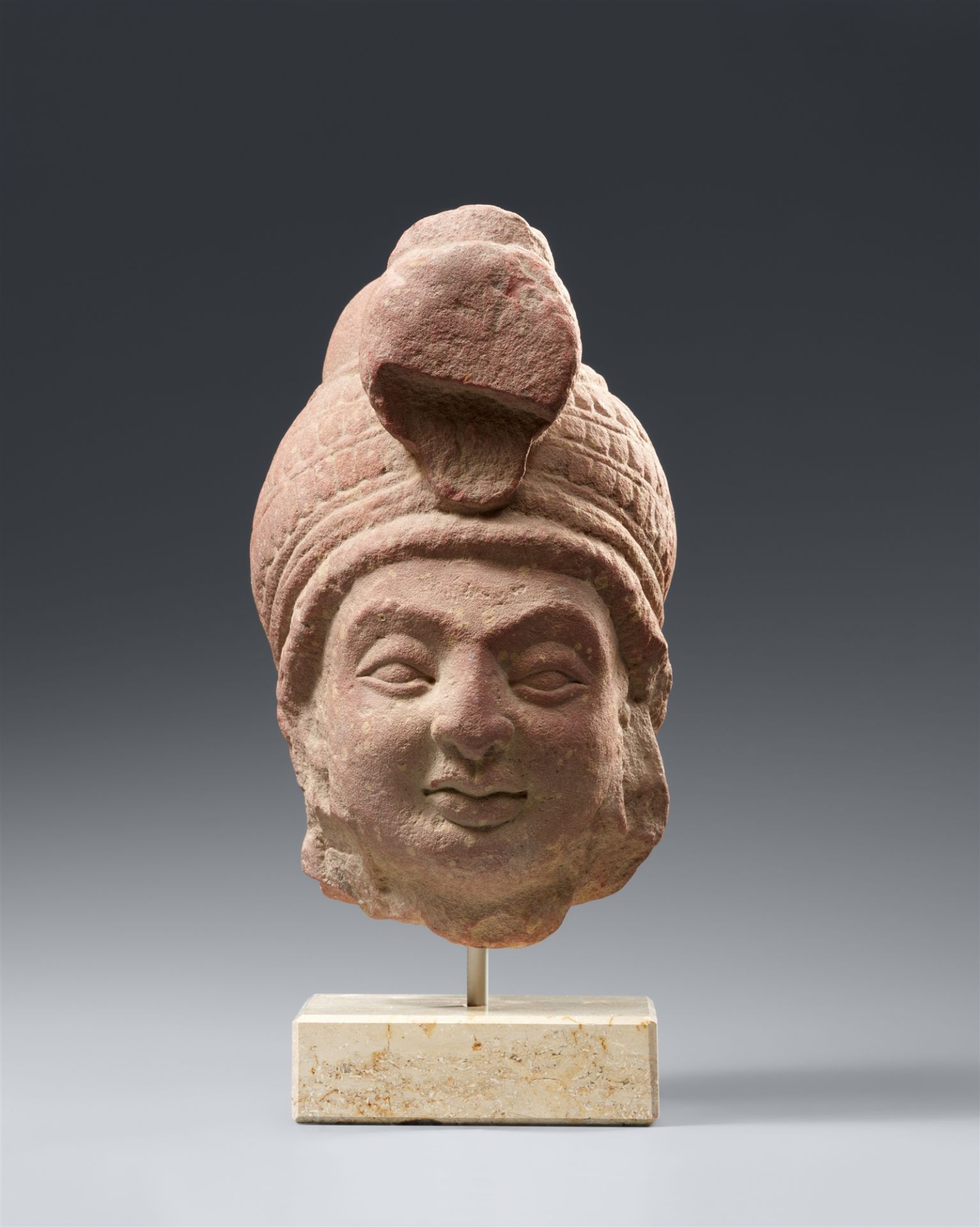 A Mathura mottled pink sandstone head of a bodhisattva. Northern India, Kushana empire. Around 2nd c