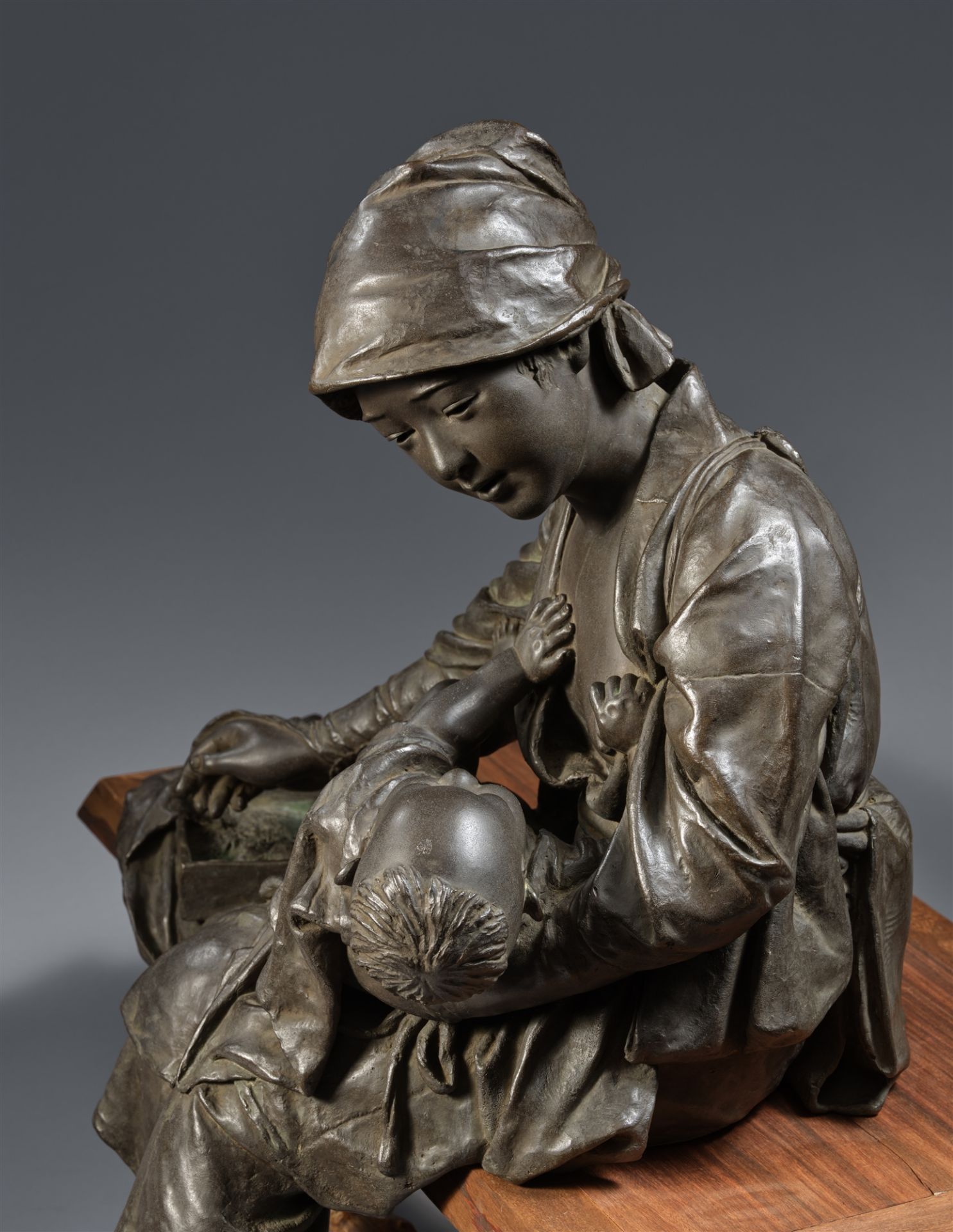 An Udagawa Kazuo cast bronze figure of a young mother with her child, seated on a wooden bench. Toky - Image 3 of 4