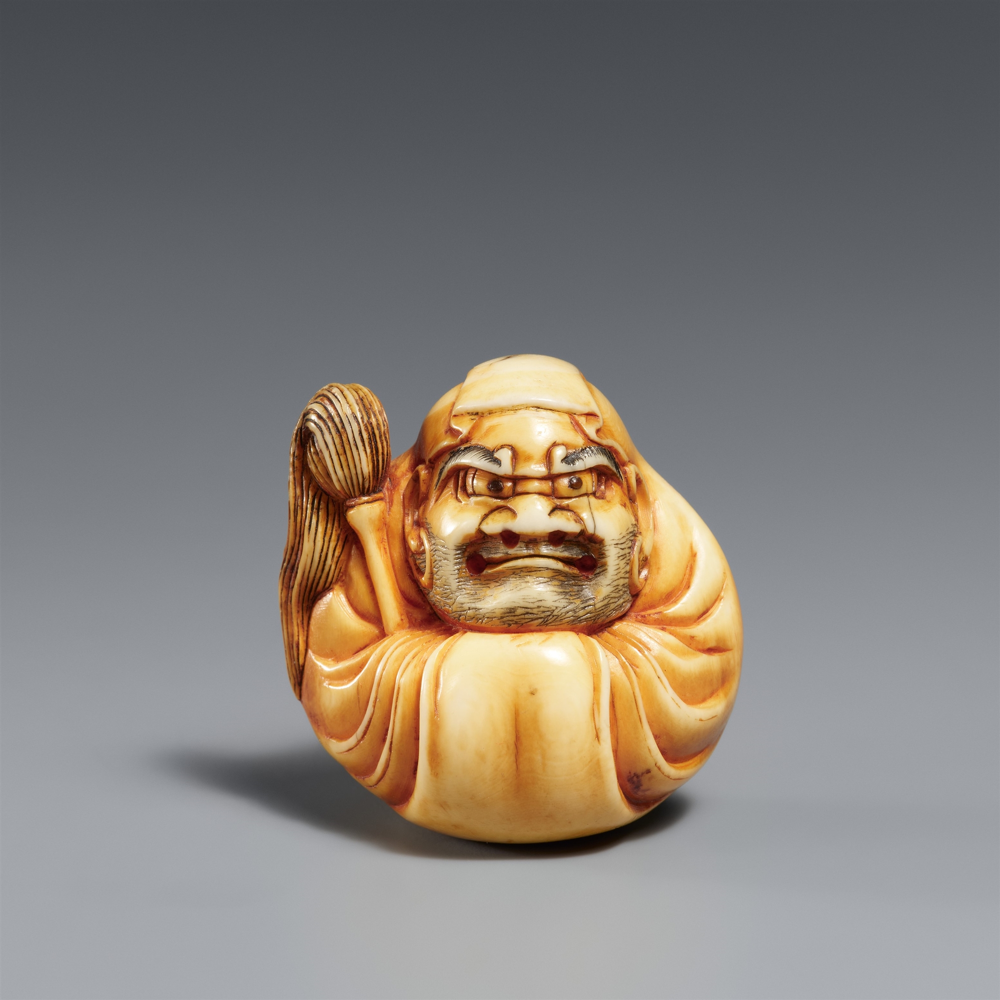 A stained ivory netsuke of a Daruma doll. Osaka. Ca. 1860