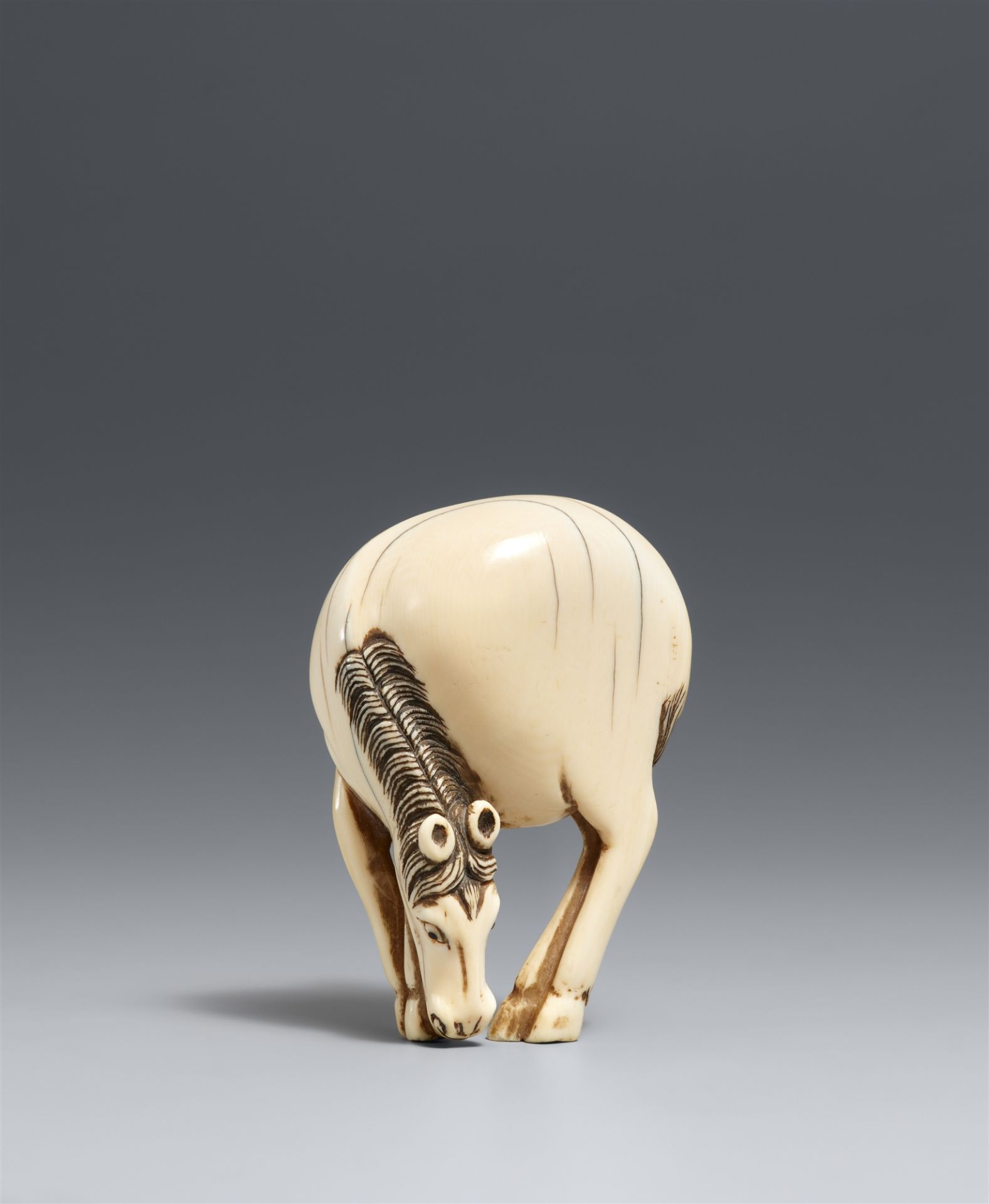 A large ivory netsuke of a grazing horse. Late 18th century