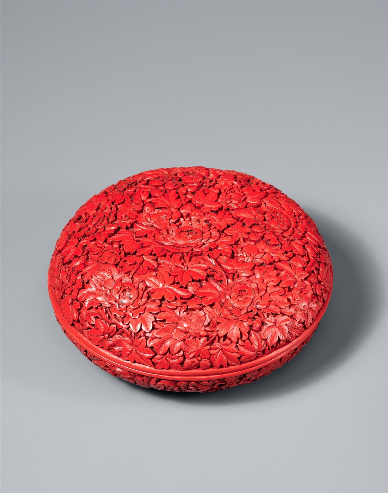 A round carved red lacquer box. 18th century