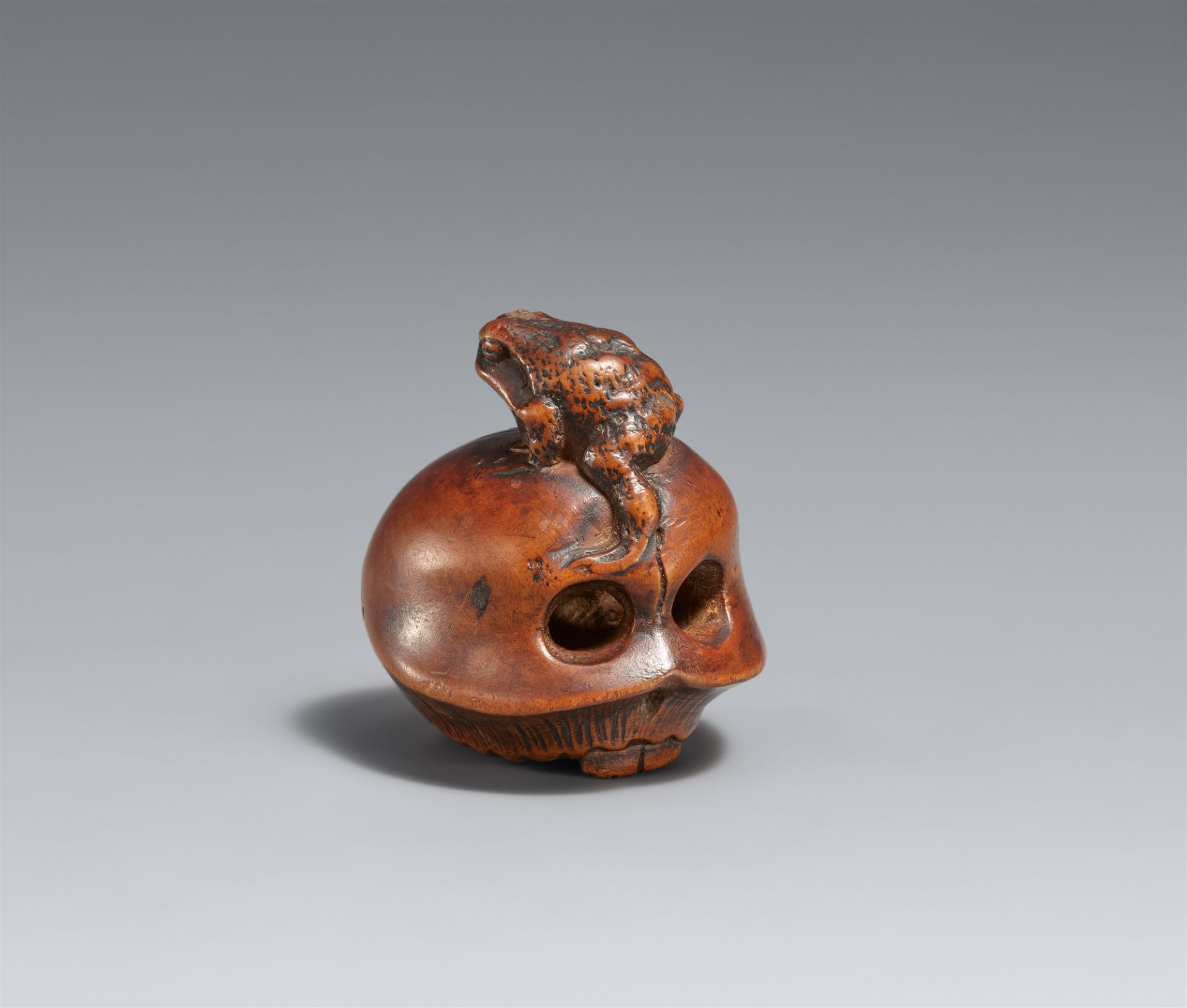 A boxwood netsuke of a skull and toad. Second half 19th century