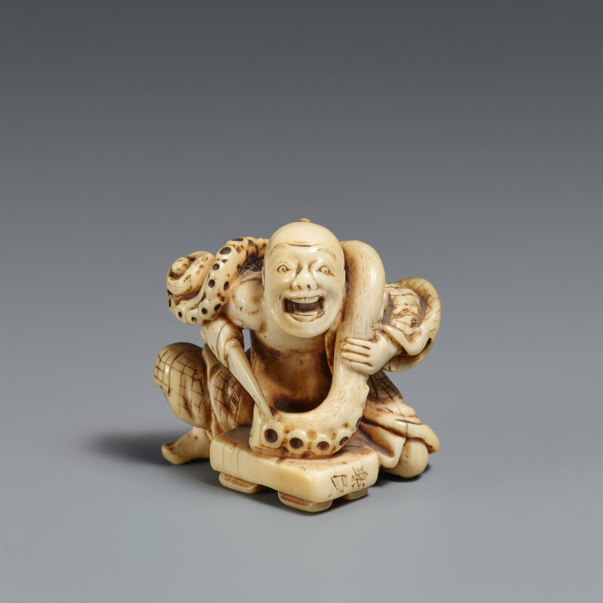 An ivory netsuke of a cook with an octopus tentacle. Mid-19th century