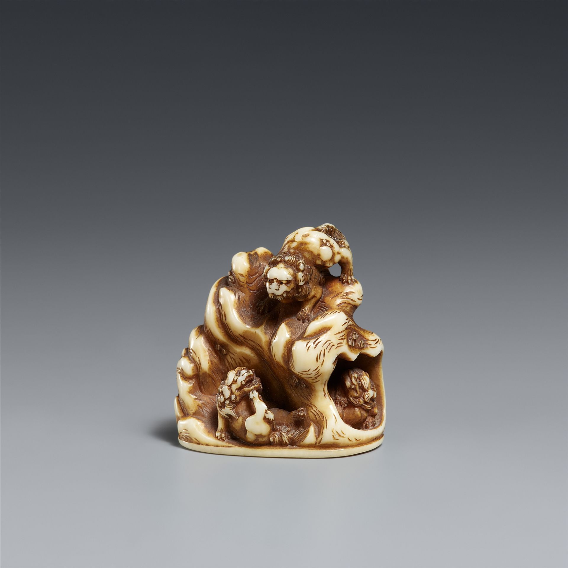 A stained ivory netsuke of five shishi. Mid-19th century
