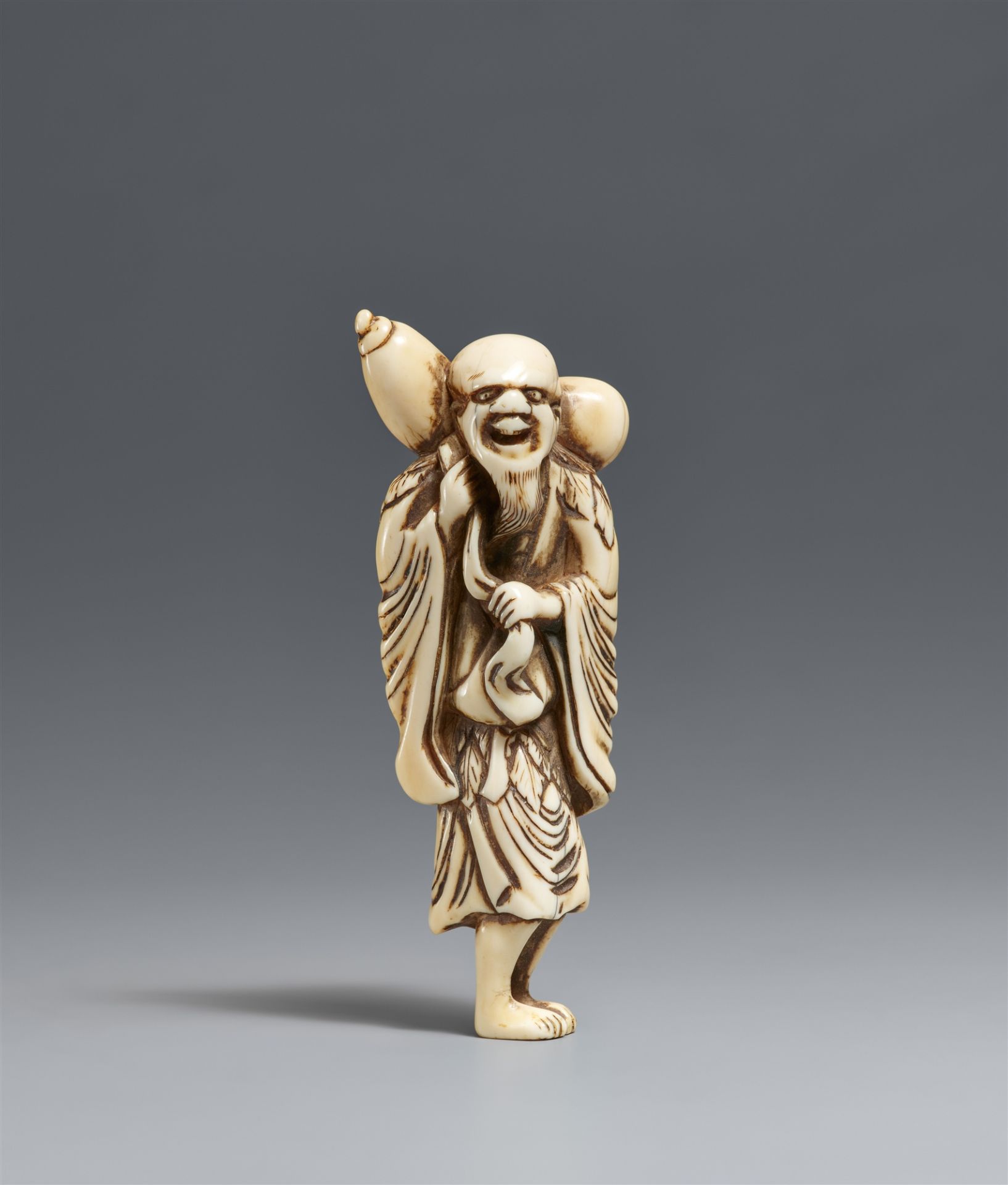 An ivory netsuke of a tall sennin. 18th century