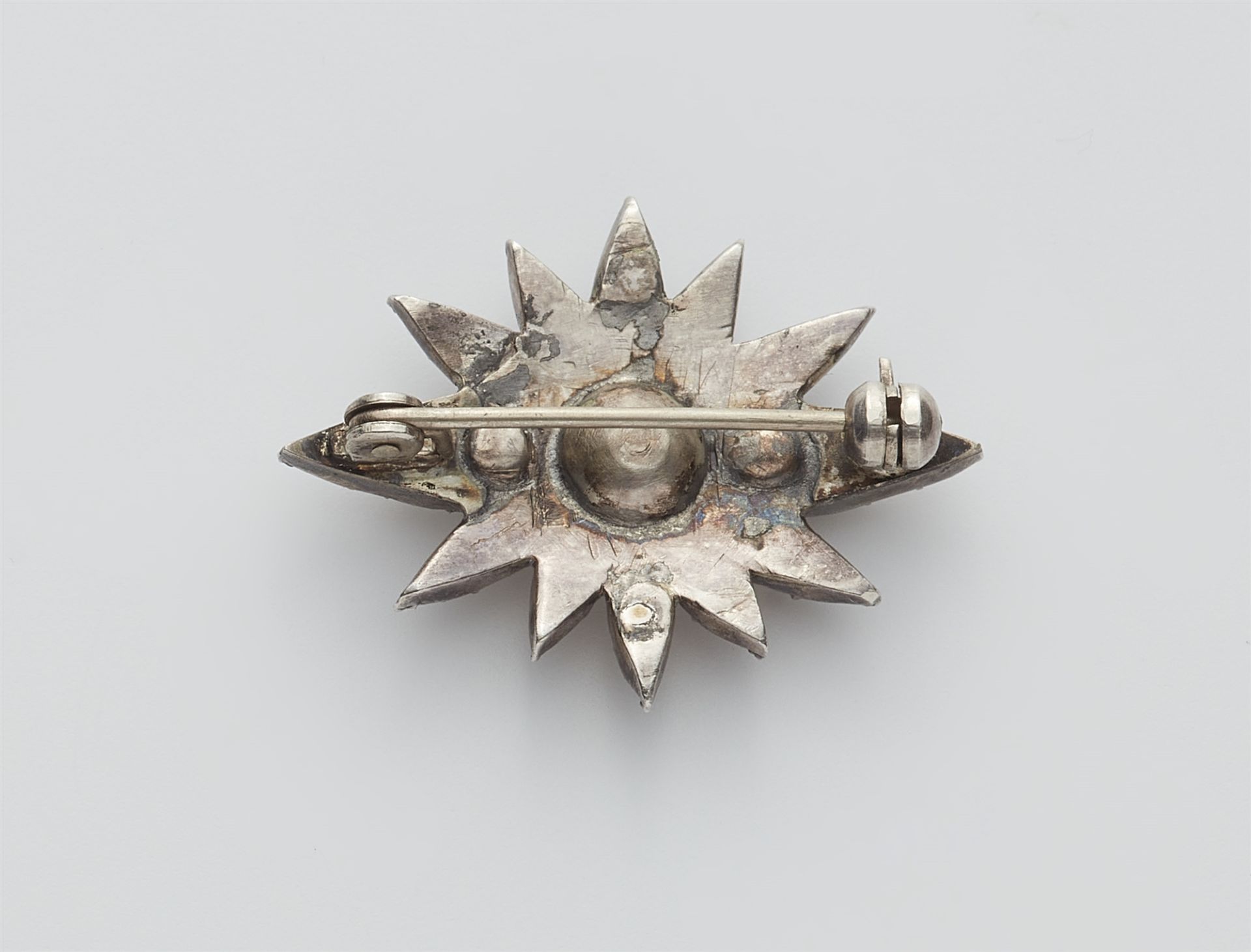 A small silver and cushion-cut diamond star brooch. - Image 2 of 2