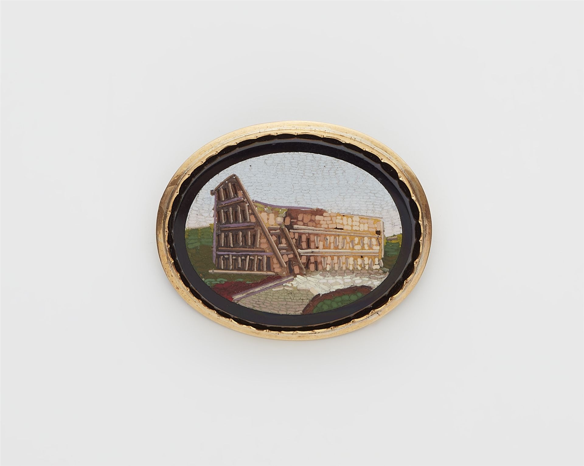 A 14k gold and Roman micromosaic souvenir brooch depicting the Colosseum.