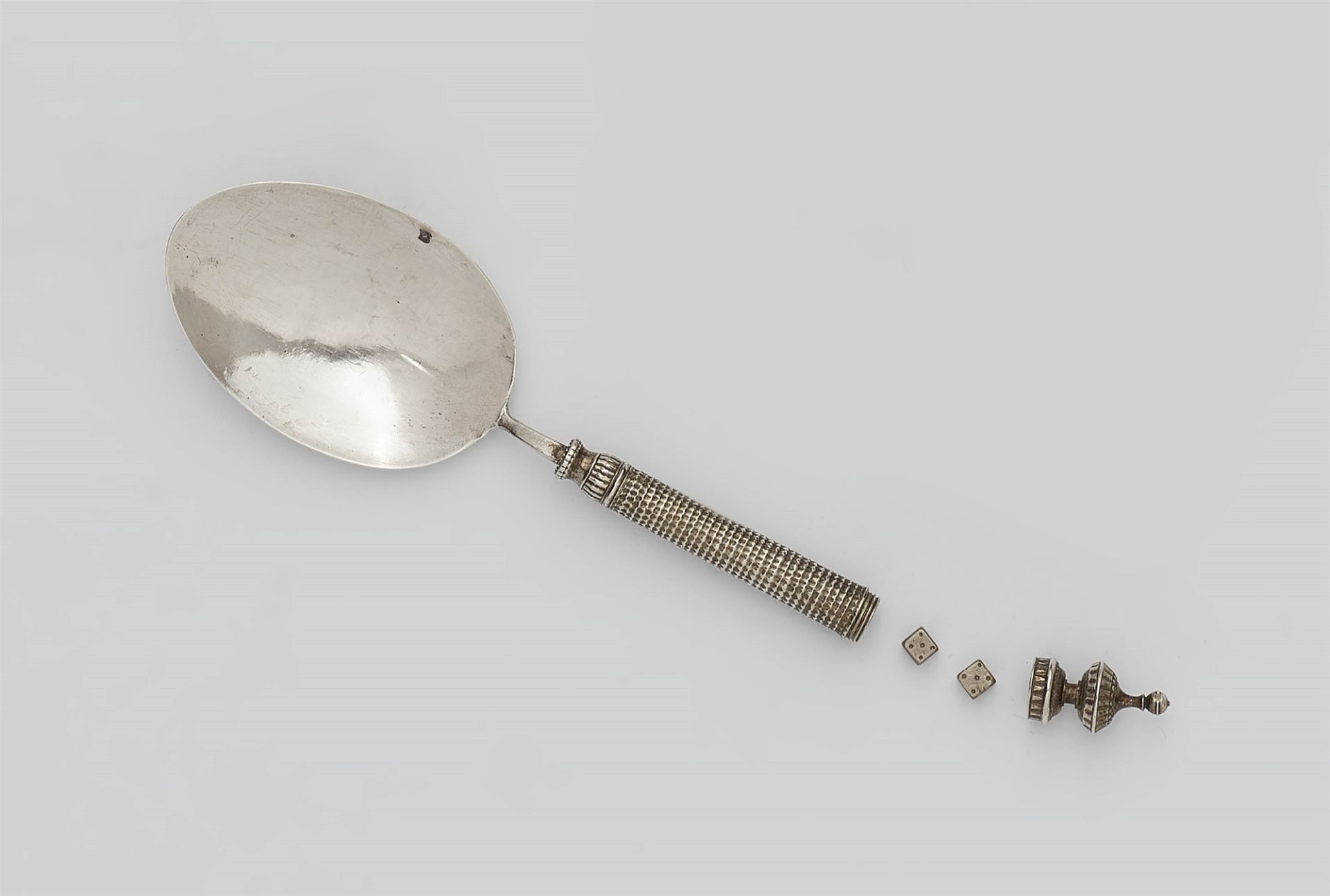 A silver spoon with screw mounted compartment