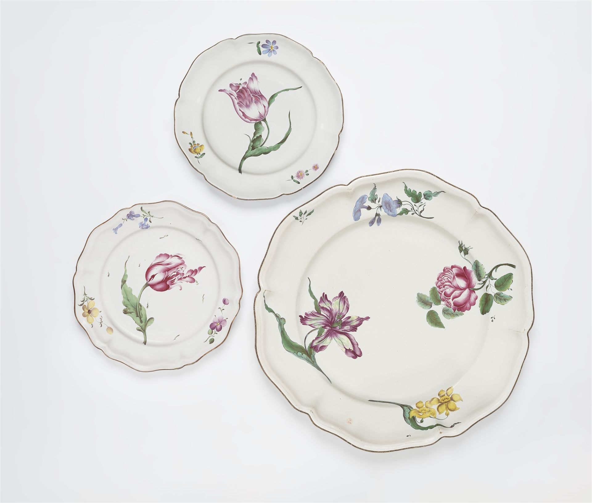 Runde Platte und zwei Teller mit 'fleurs esseulées'