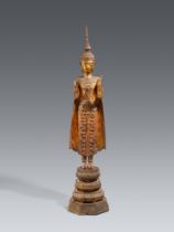 A large and slender Ratanakosin gilded and lacquered bronze figure of a crowned and bejeweled Buddha