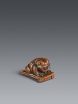 A boxwood netsuke of a toad on a roof tile. 19th century