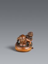 A boxwood netsuke of Daruma or rakan being washed by an oni. Second half 19th entury