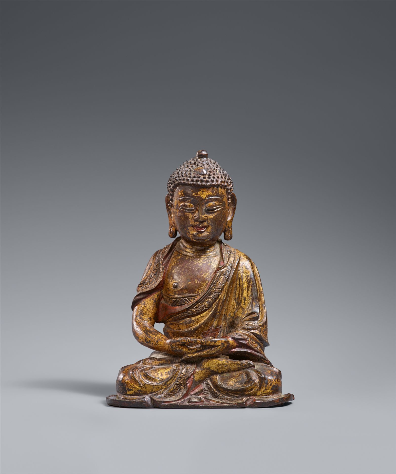 A small gilded and lacquered bronze figure of Buddha Shakyamuni. Ming dynasty, 16th century